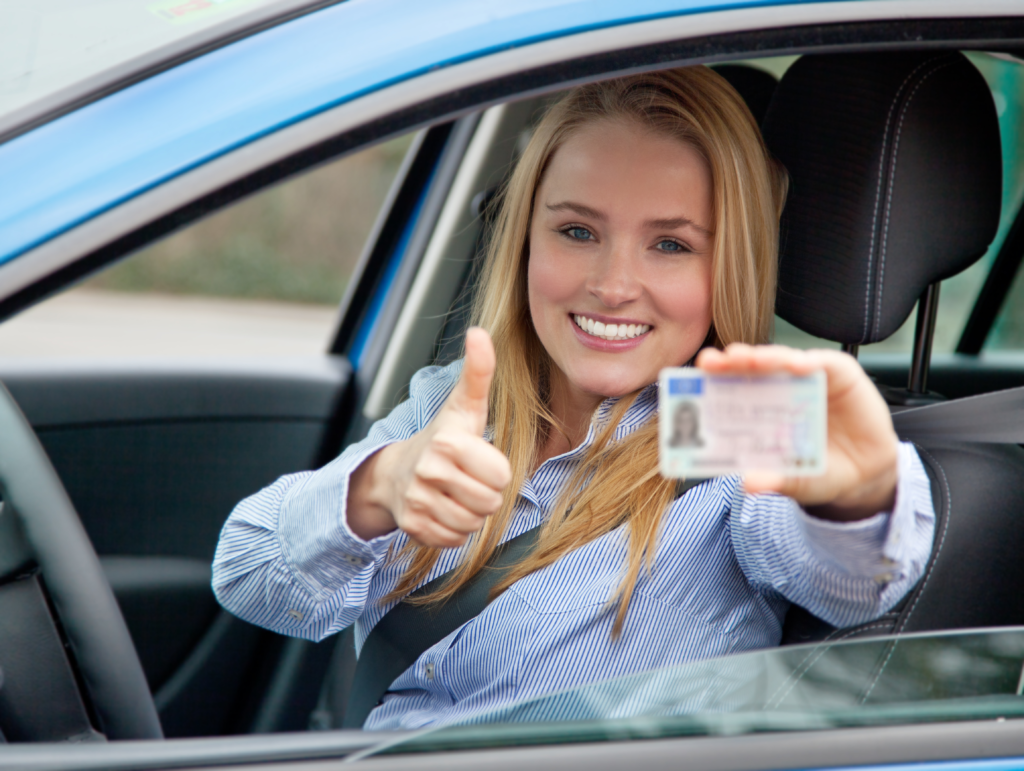 Attractive woman in car showing her european drivers license.